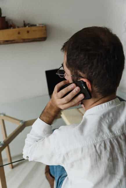 Adult male making a phone call in a minimalist home office setting.